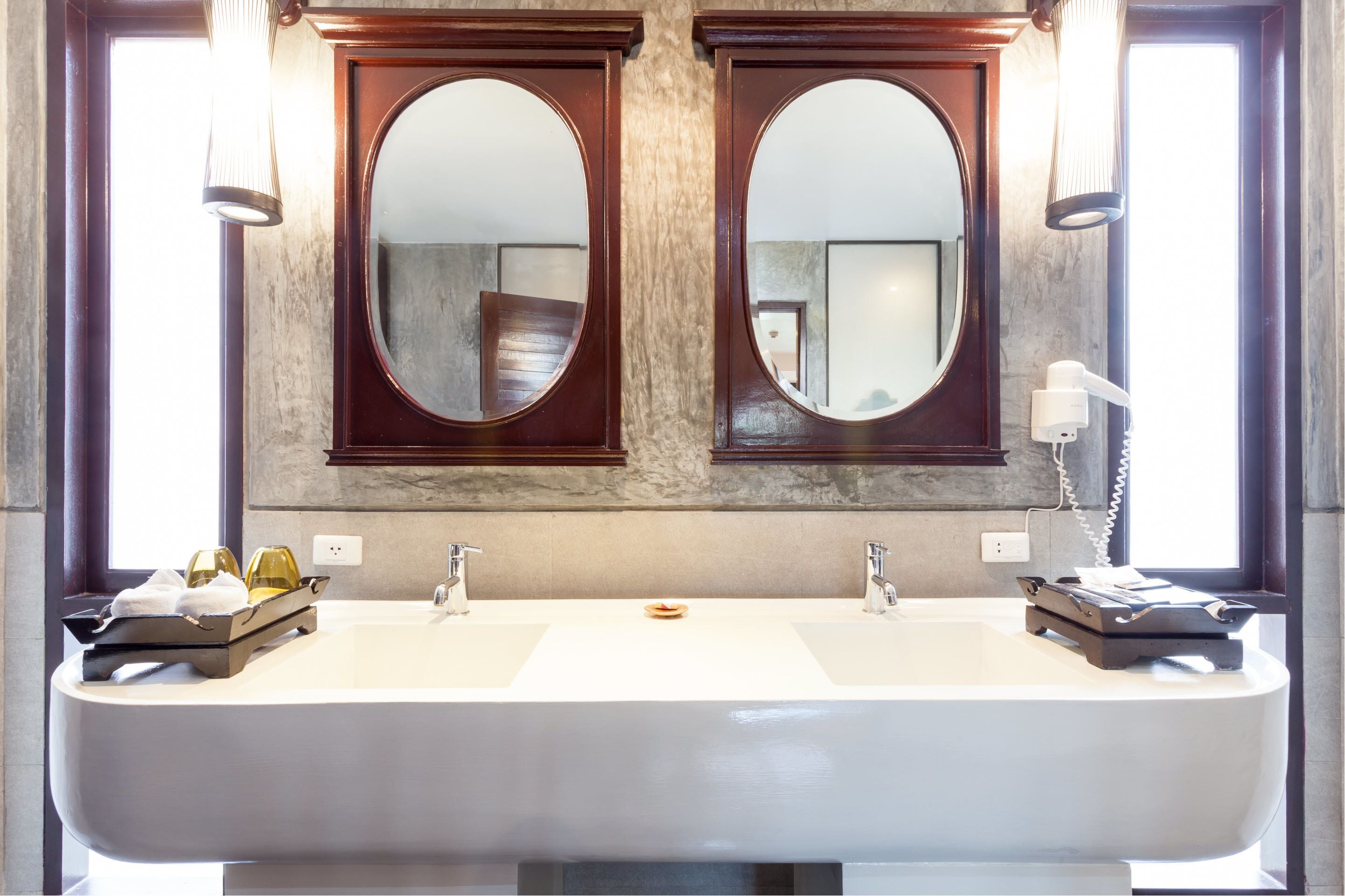 A bathroom with two sinks, a large mirror, and a towel rack.