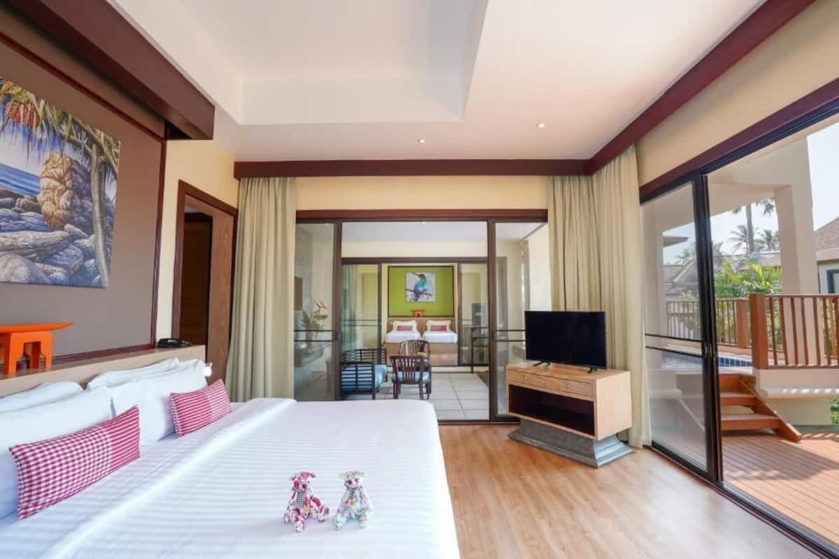 Habitación de hotel con una cama grande, televisión, escritorio y balcón con vista al océano.