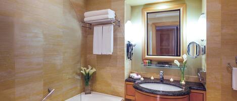 A bathroom with a bathtub, sink, and mirror.