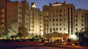 Un hotel grande de varios pisos con un cartel llamativo que dice "Mövenpick".