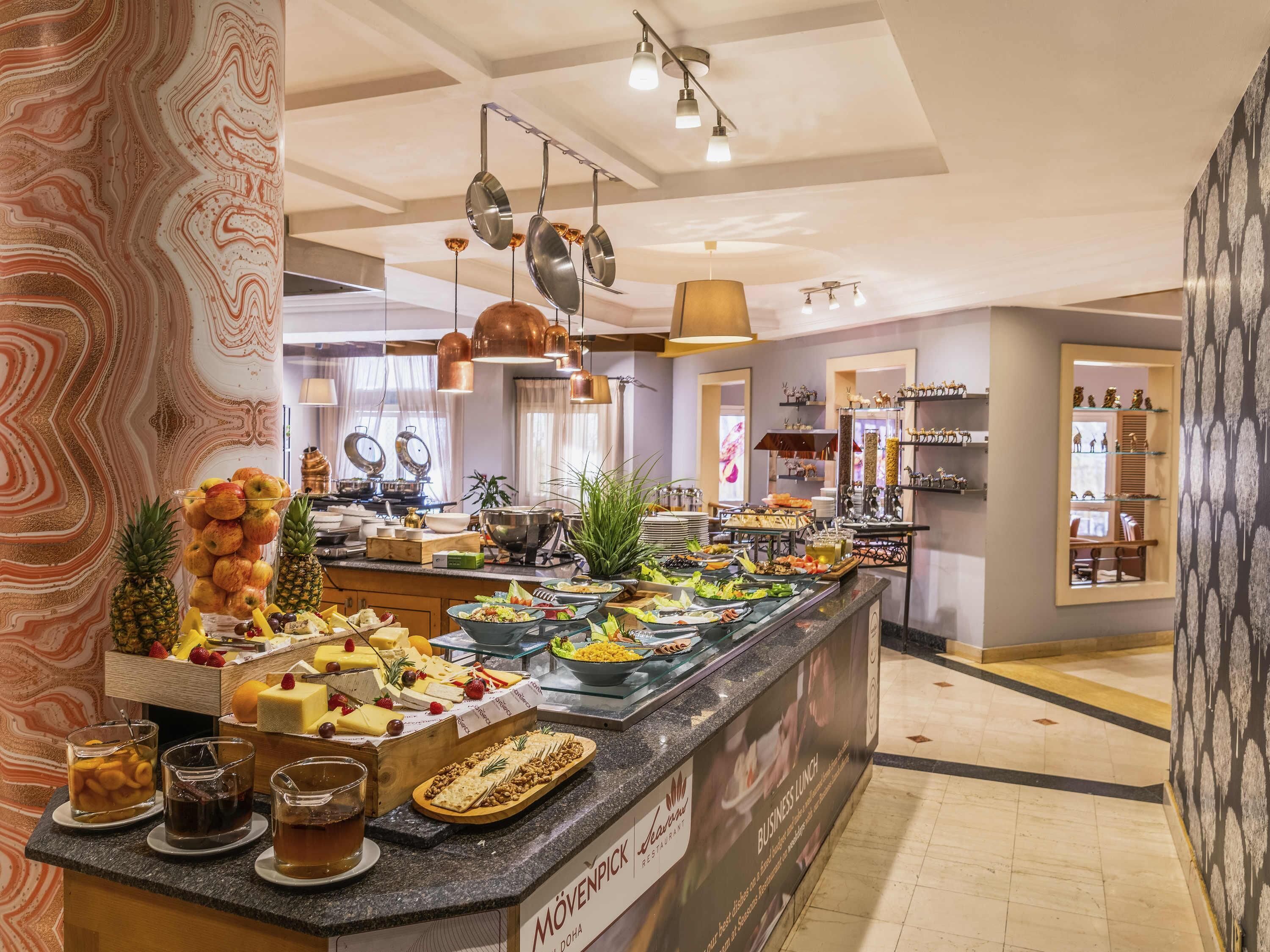 A buffet area with various food items, a coffee station, and a sign indicating 'Mövenpick Restaurant'.