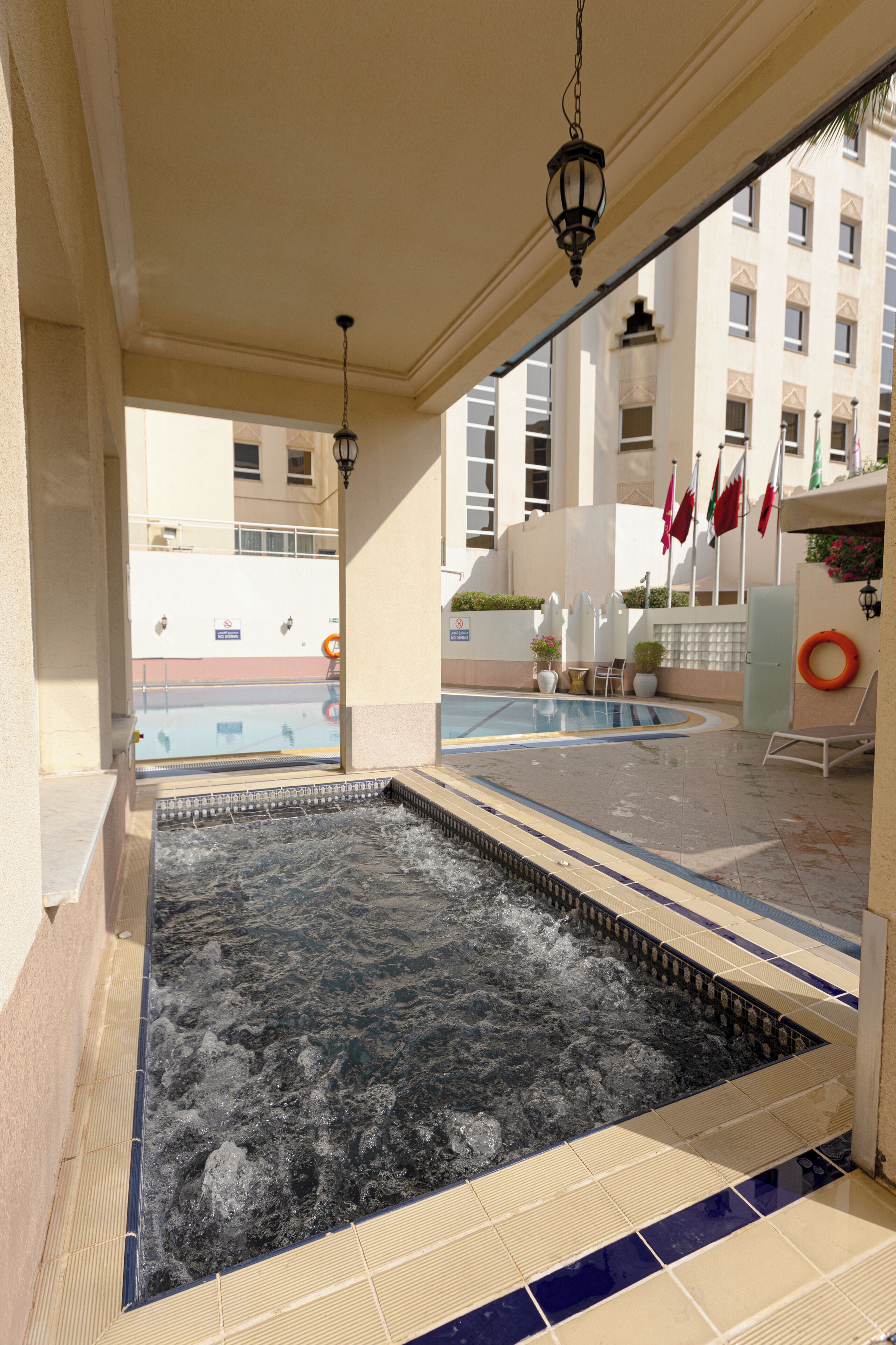 Et spaområde med jacuzzi, liggestole og en pool.