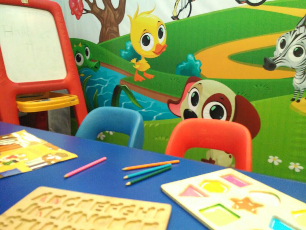 A children's play area with a table, chairs, and educational toys.