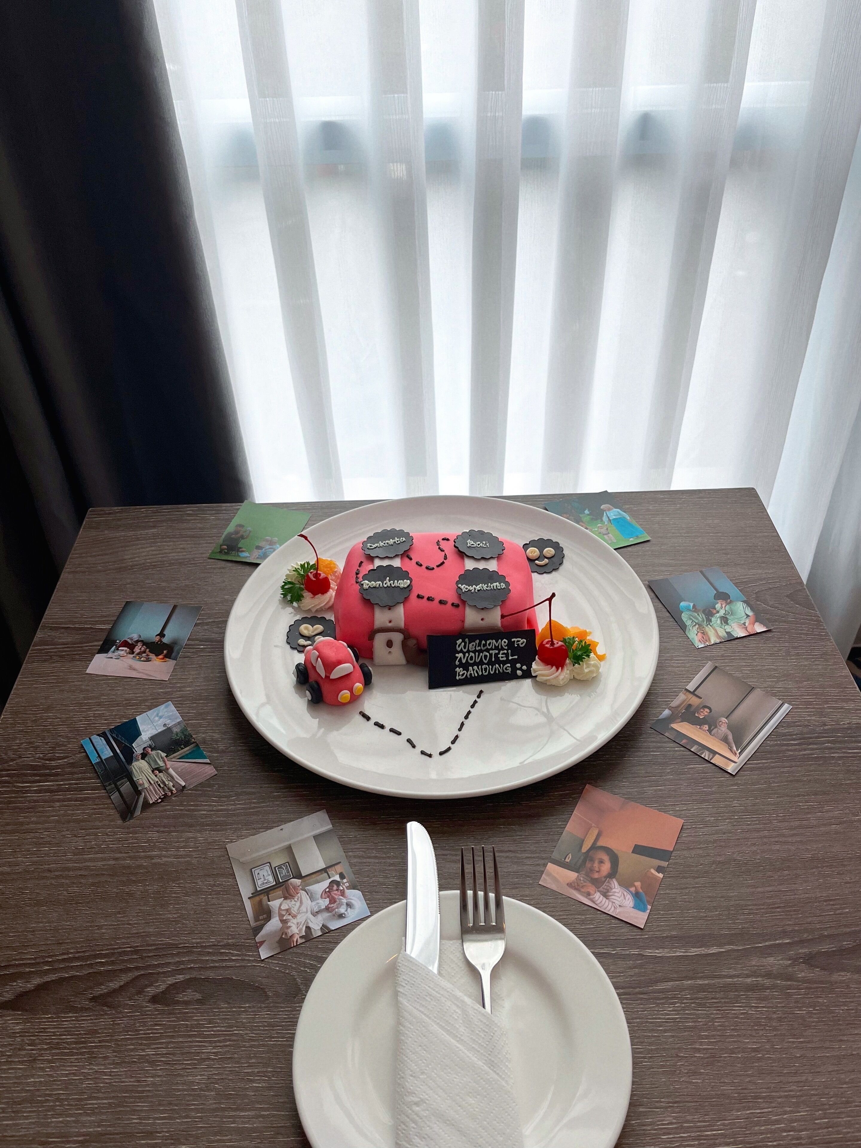 Een tafel met een taart versierd met een trein en een bordje met de tekst 'Welcome to Zovotel Bandung'.