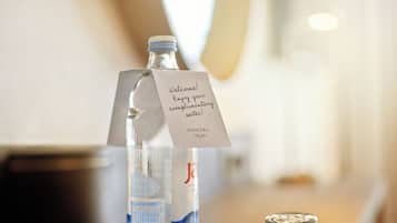 Une bouteille d’eau avec une étiquette et une étiquette supplémentaire indiquant : « Bienvenue ! Profitez de cette bouteille d’eau offerte ! »