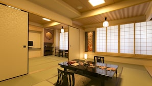 A traditional Japanese room with tatami flooring, a low table with cushions, and sliding doors. - Matsui Honkan (Kyoto)