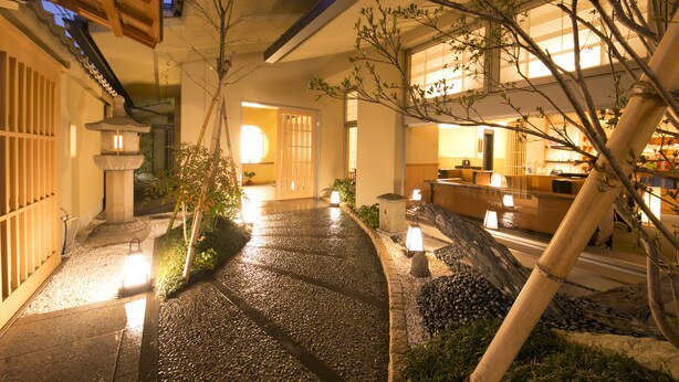 A traditional Japanese-style courtyard with stone pathways, lanterns, and a reception area. - Matsui Honkan (Kyoto)
