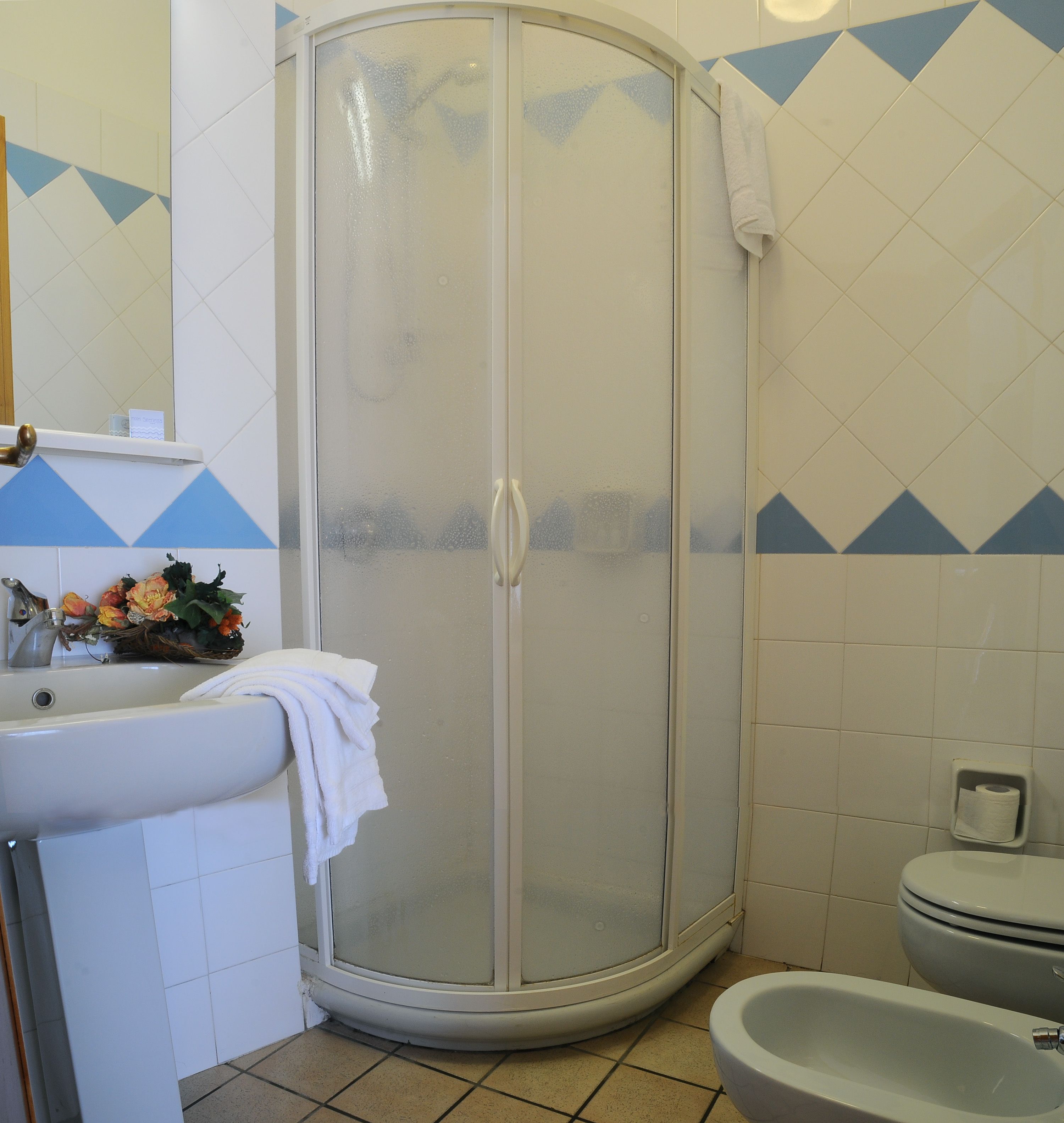 A bathroom with a shower, sink, and toilet.