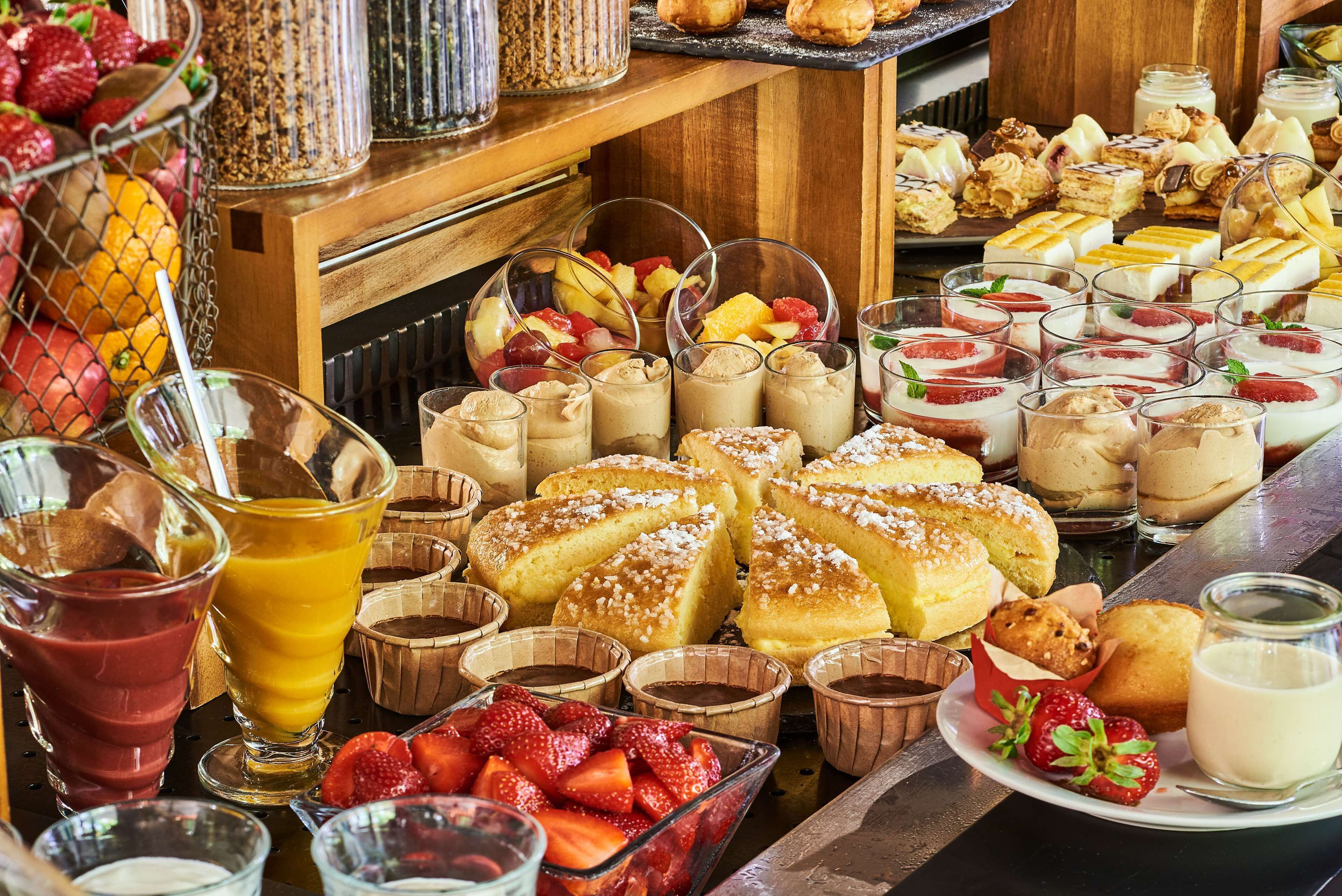 A breakfast buffet with various pastries, fruits, and beverages.