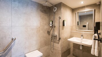 Un baño moderno con ducha, inodoro y lavabo.