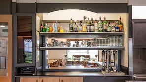 A bar area with shelves of liquor bottles and glasses.