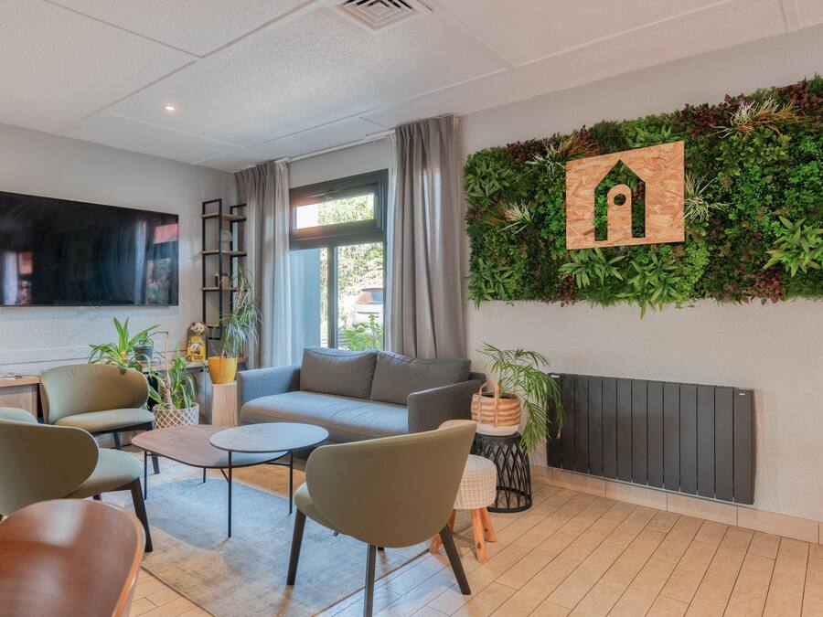 Uma sala de estar moderna com sofá, poltronas, TV, lareira e parede verde vertical.