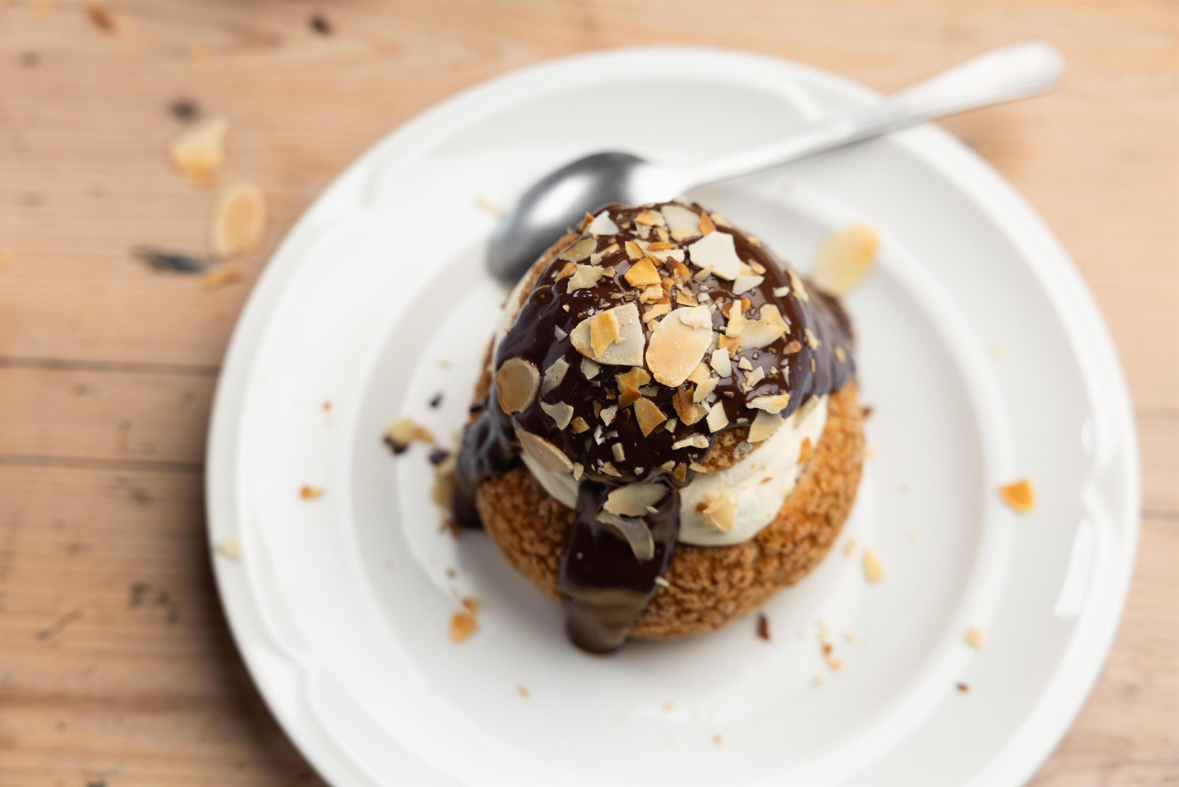 A dessert on a white plate with a spoon.