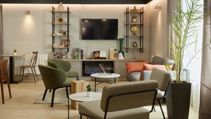 Ein modernes Wohnzimmer mit Flachbildfernseher, Bücherregalen und bequemen Sitzgelegenheiten.