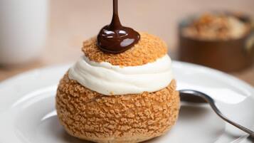 Un dessert nappé de sauce au chocolat, présenté sur une assiette blanche.