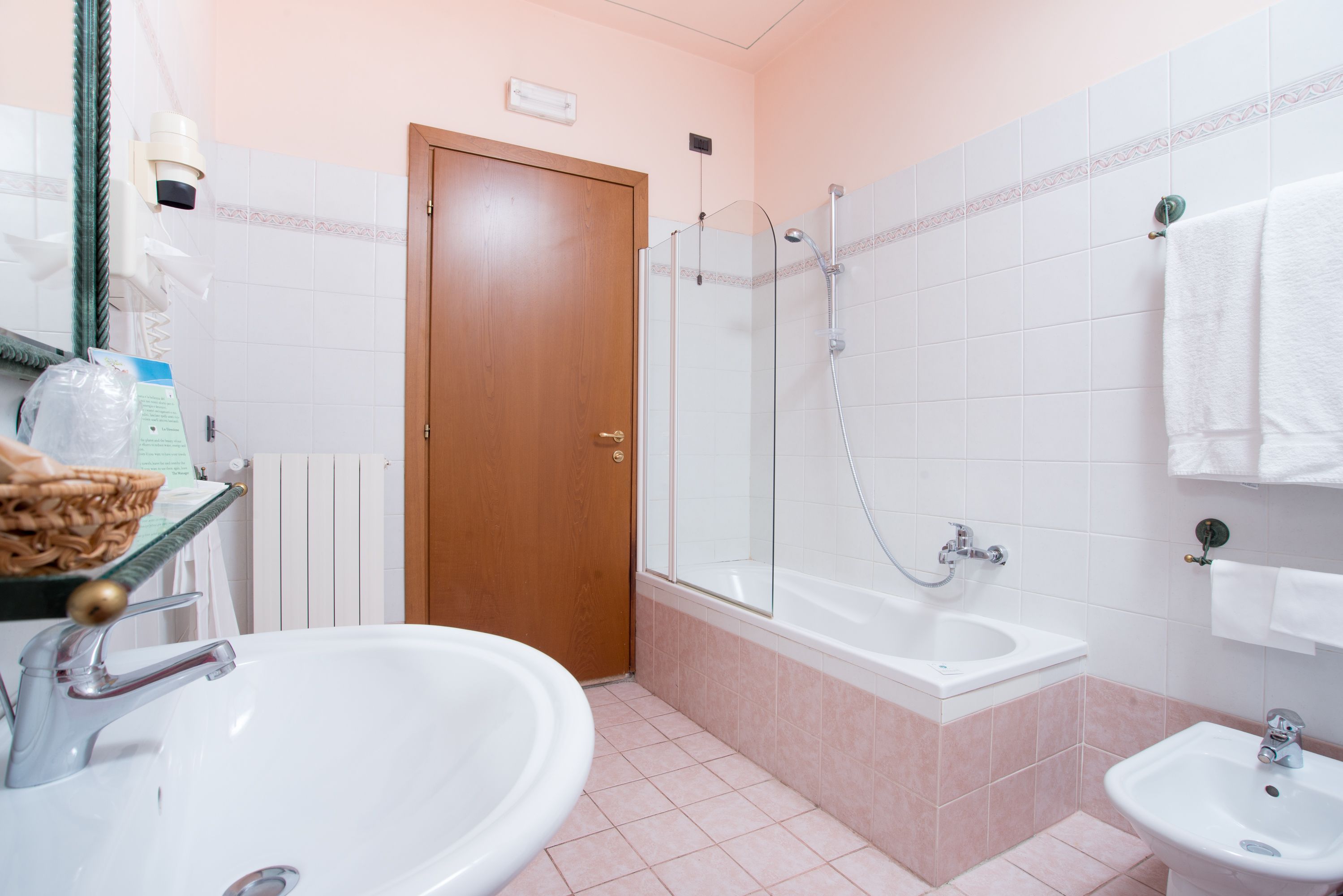 Een badkamer met een wastafel, een bad en een douche.