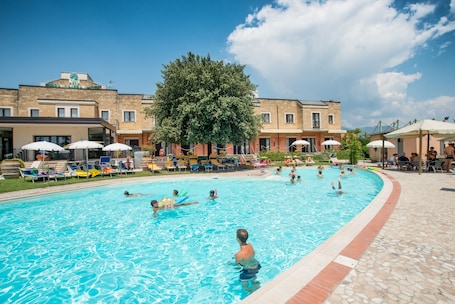 Outdoor pool, pool umbrellas, pool loungers. Terra Umbra Hotel