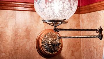 A chandelier with a floral design, a decorative base, and a wooden frame.