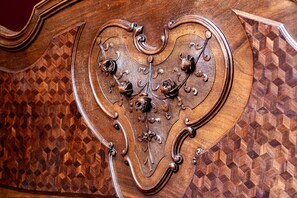 A detailed wooden panel with a heart-shaped design, featuring intricate carvings and metal accents. - Vrooman Mansion B&B (Bloomington)