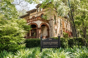 A historic building with a sign reading "701 Vrooman Mansion" and a description of its use for bed & breakfast and special events. - Vrooman Mansion B&B (Bloomington)