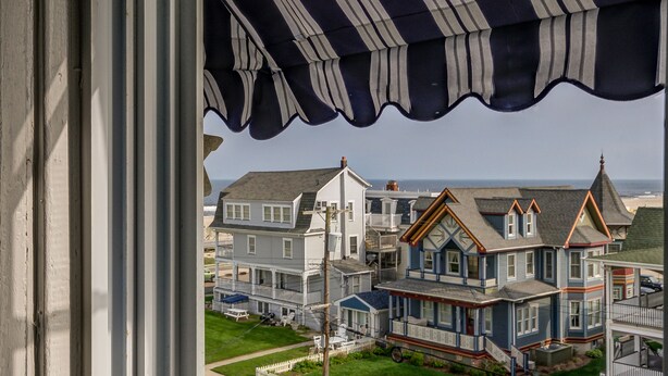 A coastal residential area with multiple houses, including a prominent blue house with a gabled roof and a white house with a balcony. - The Lillagaard B&B (Ocean Grove)
