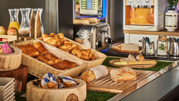 A breakfast buffet with various breads, pastries, and condiments. - Kyriad Direct Epinal (Epinal)