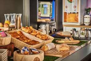 Een ontbijtbuffet met verschillende broden, gebak en toevoegingen.