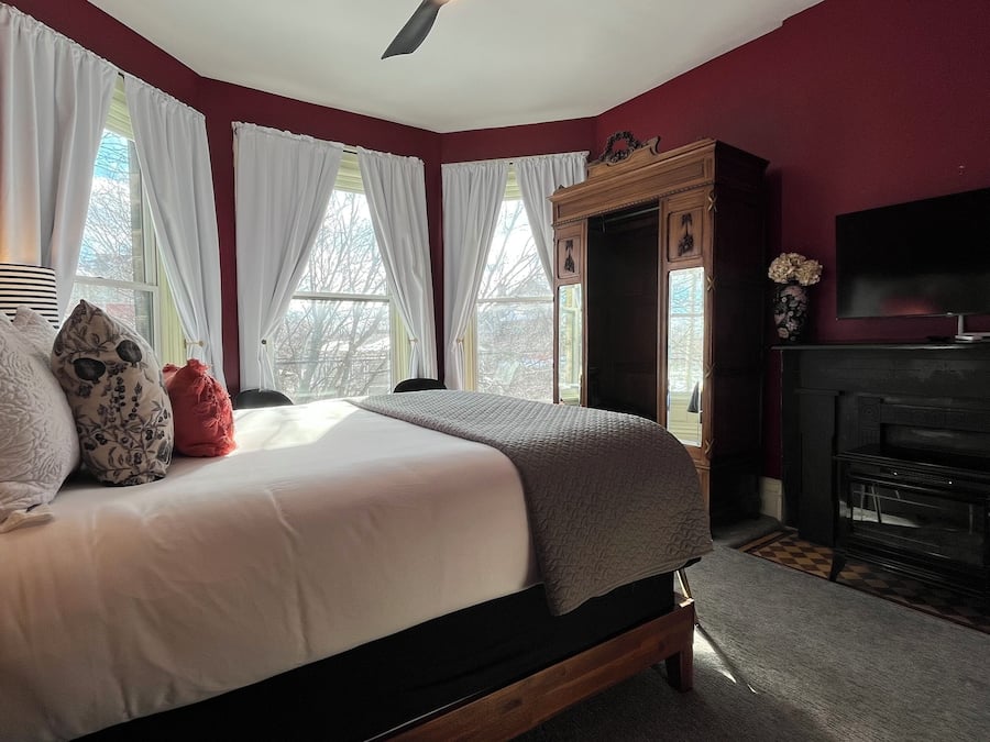 A bedroom with a bed, a fireplace, and a television.