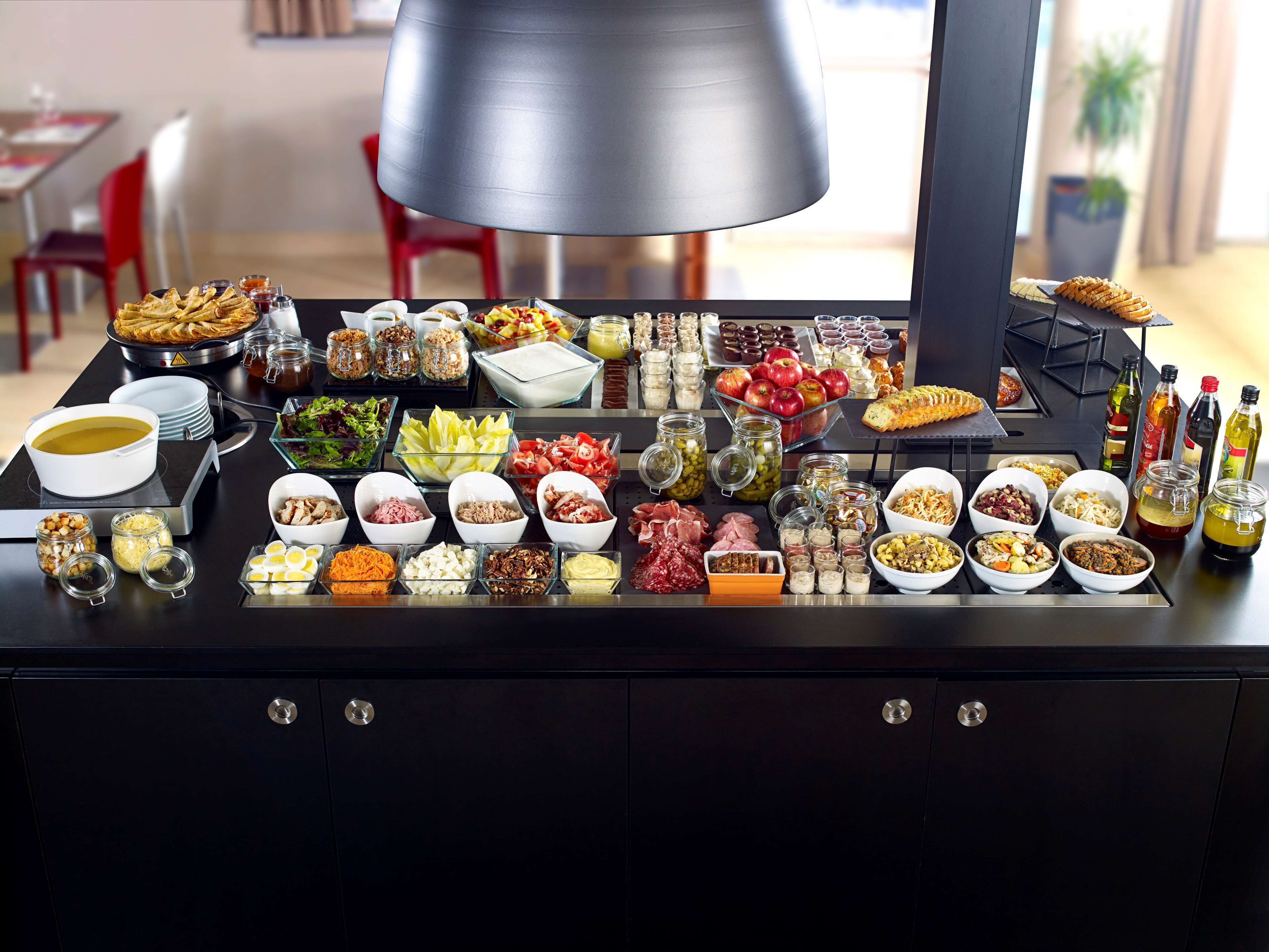 A buffet table with various food items and condiments.