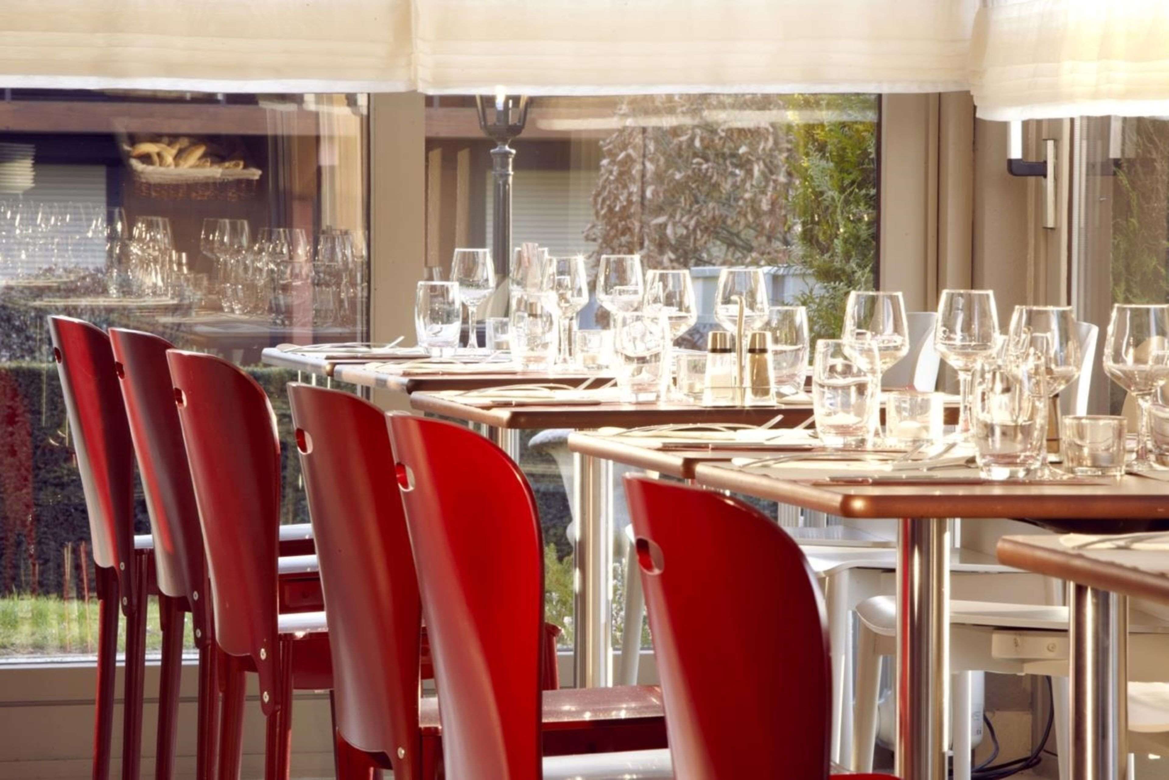 A restaurant with multiple tables set for dining, each with chairs and glassware.