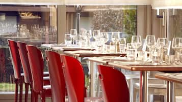 A restaurant with multiple tables set for dining, each with chairs and glassware.