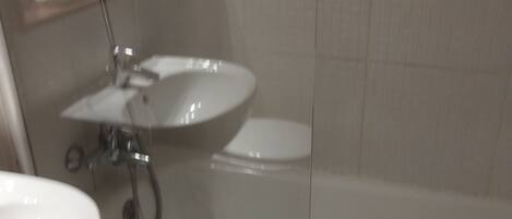 A bathroom with a sink, toilet, and bathtub.
