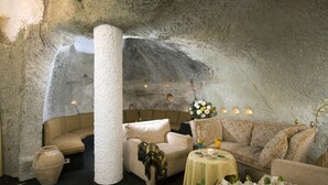 Un interior acogedor con paredes de piedra, un pilar grande y zonas de estar amuebladas.