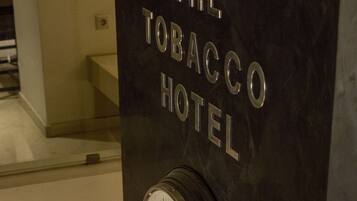 Un reloj y las palabras "The Tobacco Hotel" en una pared.