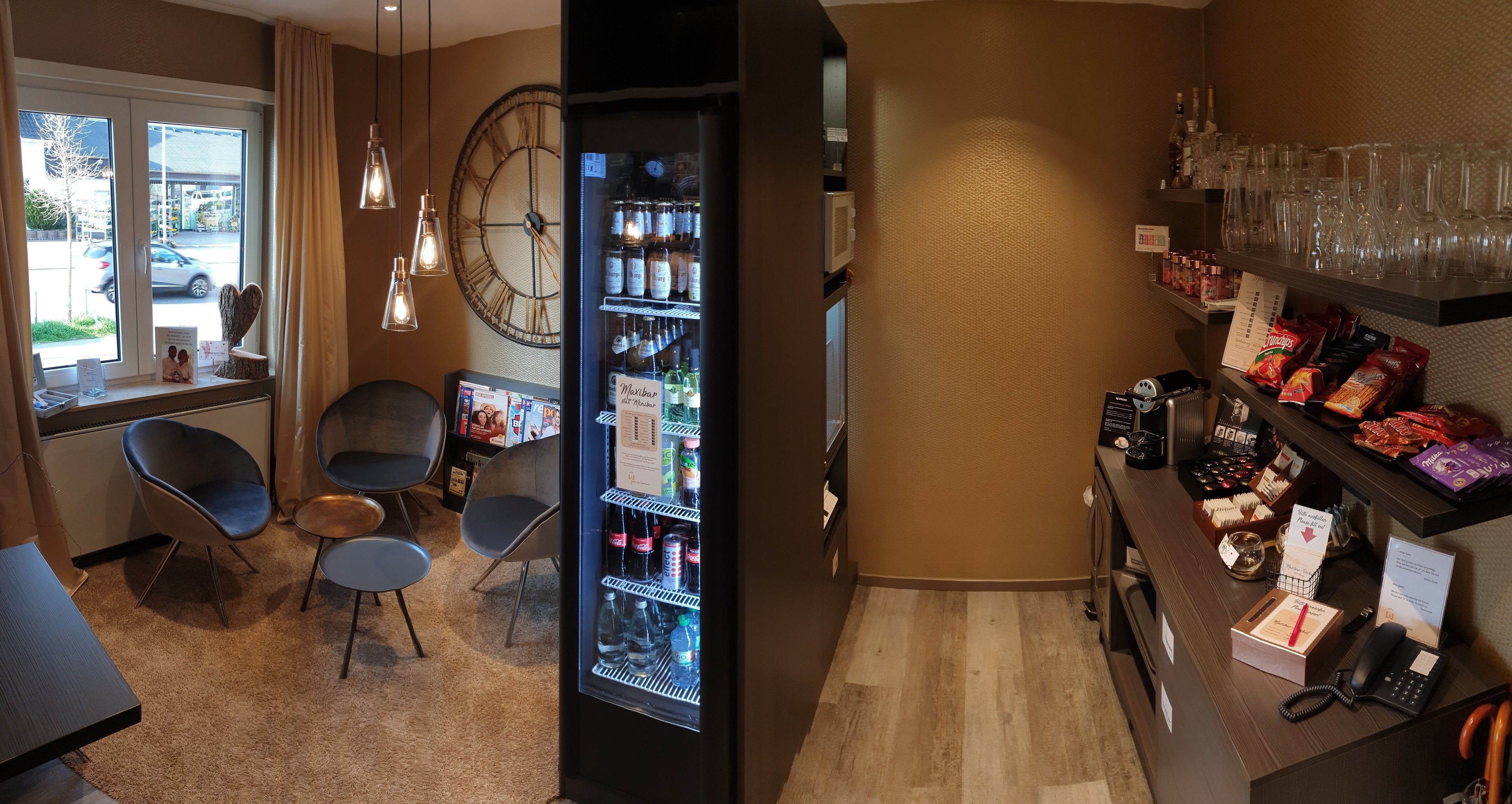 A hotel lobby with a seating area, a minibar, and a reception desk.