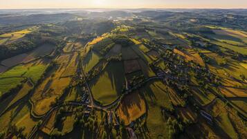 Vista aérea de un paisaje rural con campos, caminos y edificios dispersos.
