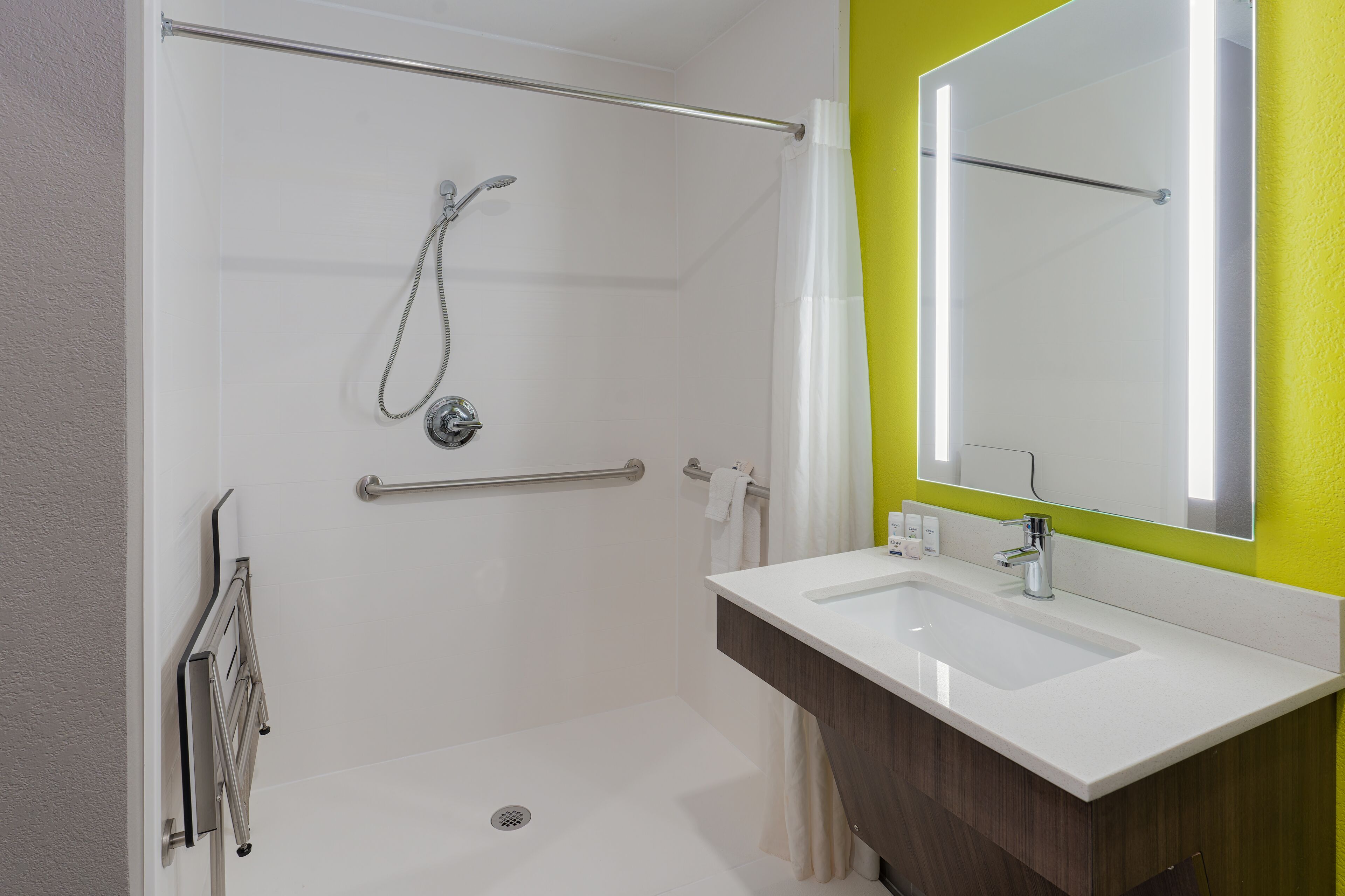 Un baño moderno con ducha, lavabo y espejo.