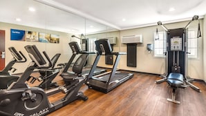 A gym with treadmills, a stationary bike, and a weight bench.