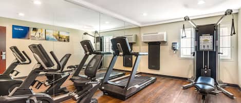 A gym with treadmills, a stationary bike, and a weight bench.