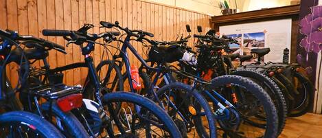 Bicycles parked in an indoor area with wooden paneling on the walls.