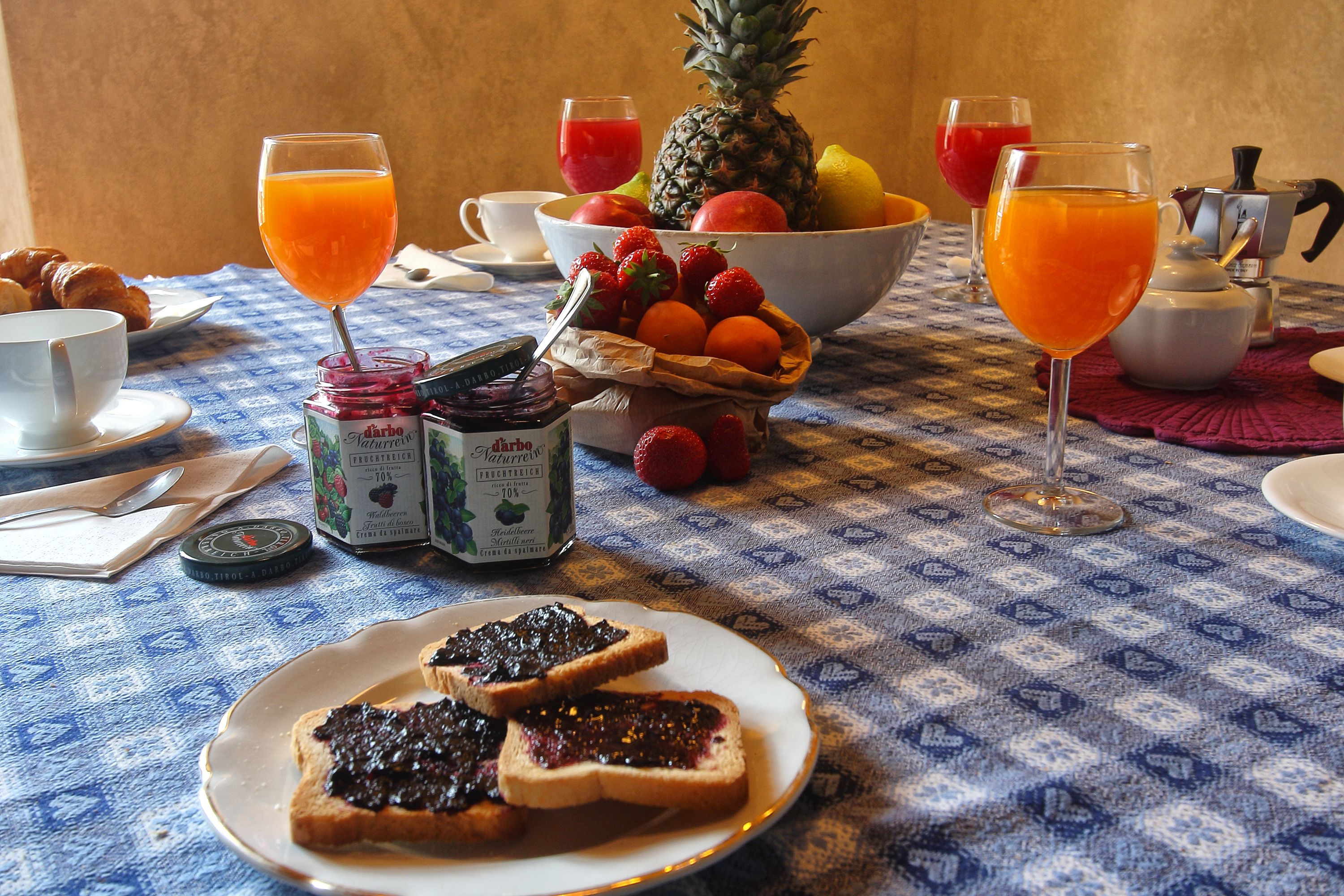 Una colazione con pane tostato, frutta e succo su un tavolo.