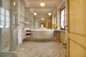 Un baño con un espejo grande, una bañera y un inodoro.