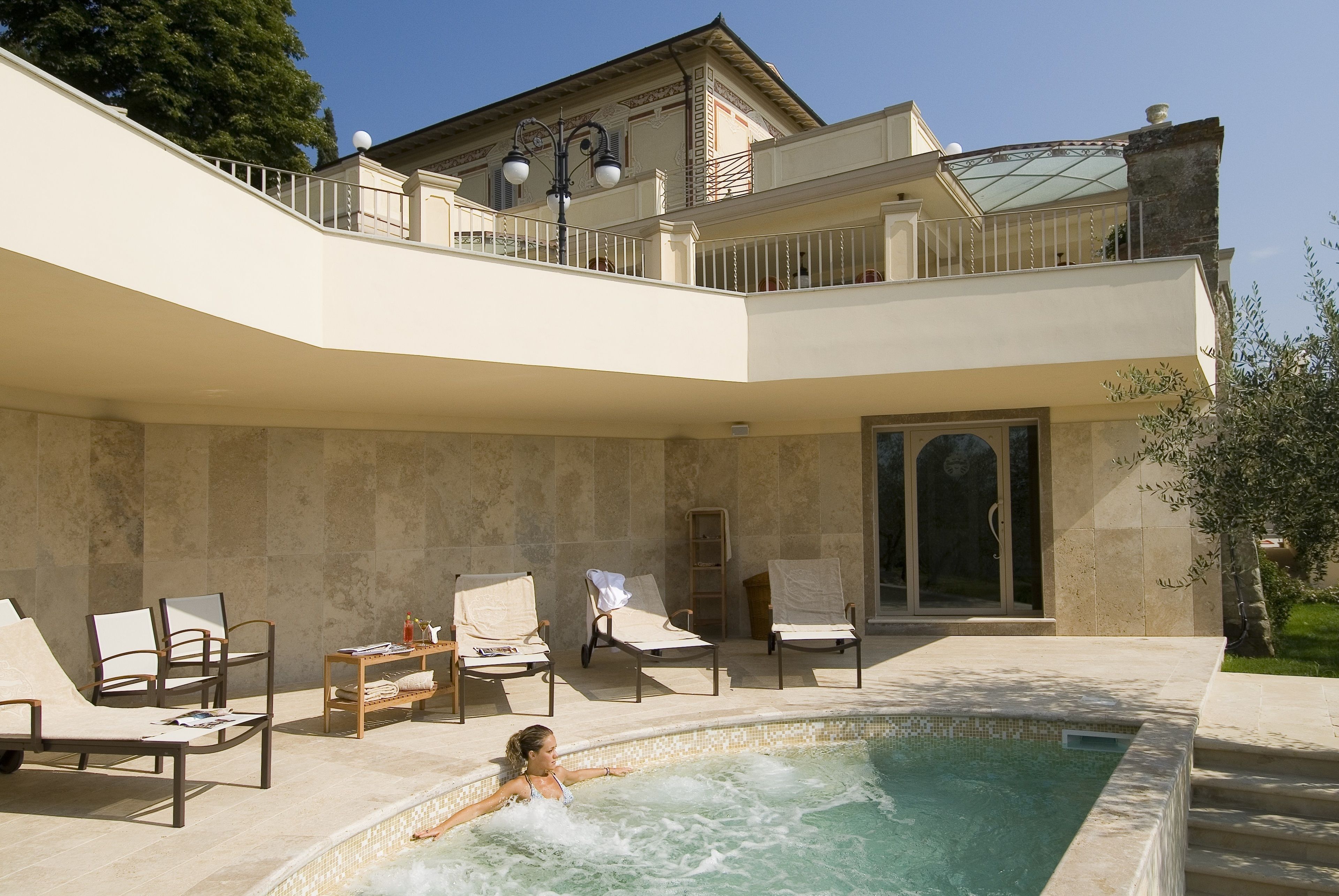 Un área de piscina con sillones de descanso y un jacuzzi.