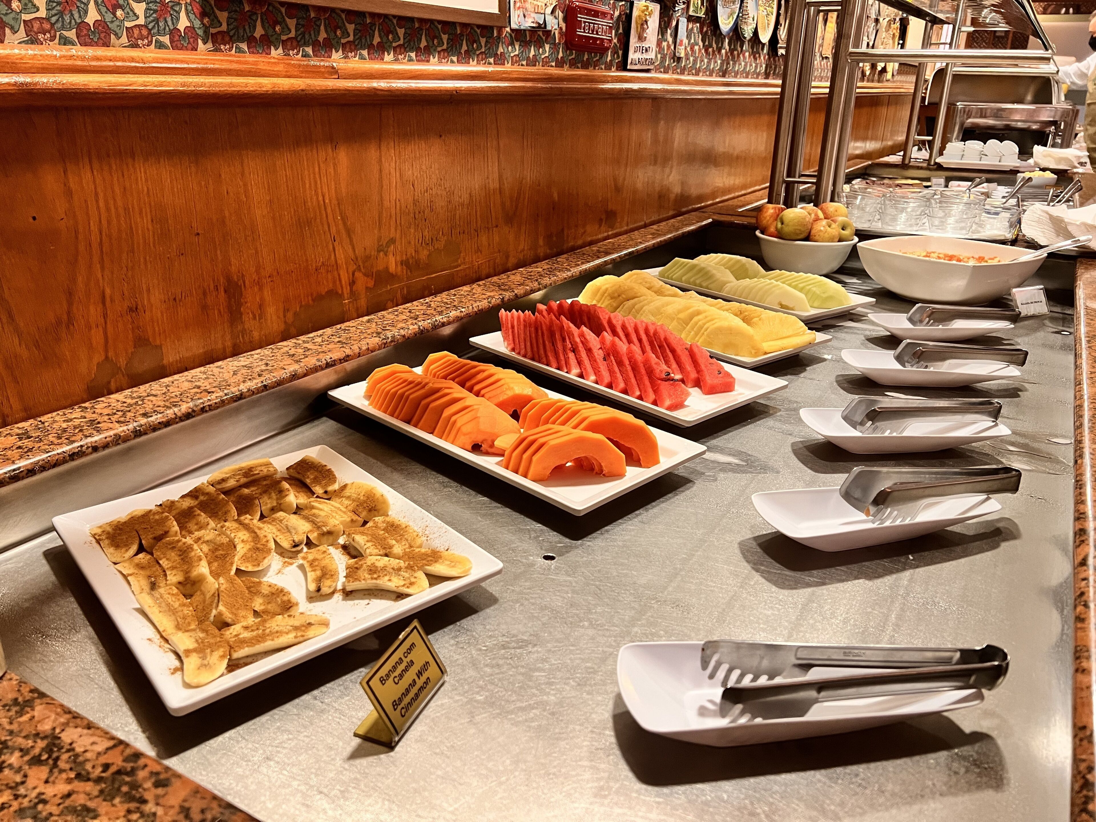 Un buffet con diversi tipi di frutta e banana bread.