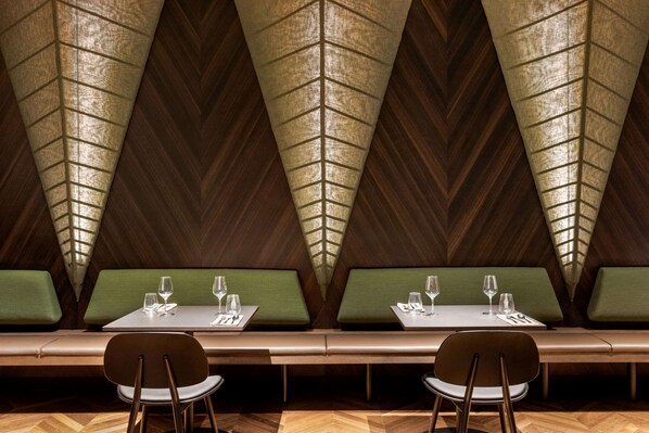 Un restaurante con asientos tipo cabina y una pared de madera con diseño de espiga.