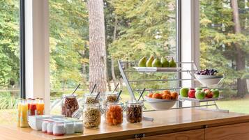 Un bufé de desayuno con diversas frutas, nueces y cereales.