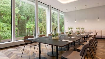 Una sala de conferencias moderna con ventanas amplias, una mesa larga y varias sillas.