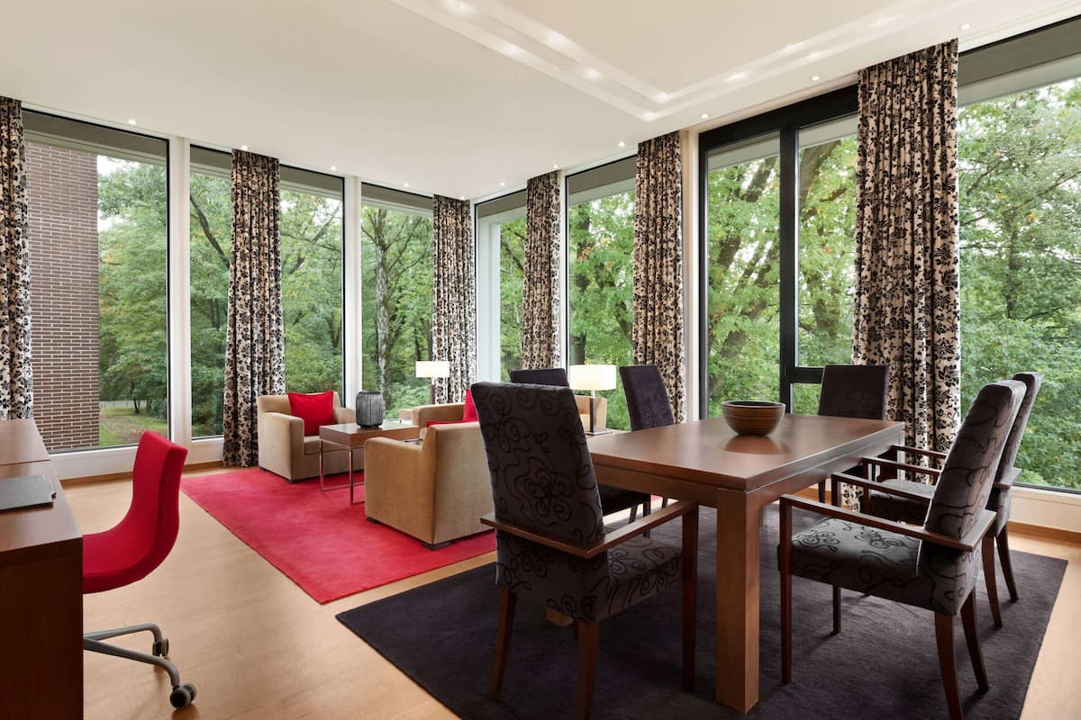 Un espace repas moderne avec une table et des chaises en bois, un canapé rouge et un tapis rouge.