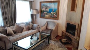 Suite de lujo, vistas a la ciudad | Sala de estar | Televisión LCD de 32 pulgadas con canales por satélite, una televisión