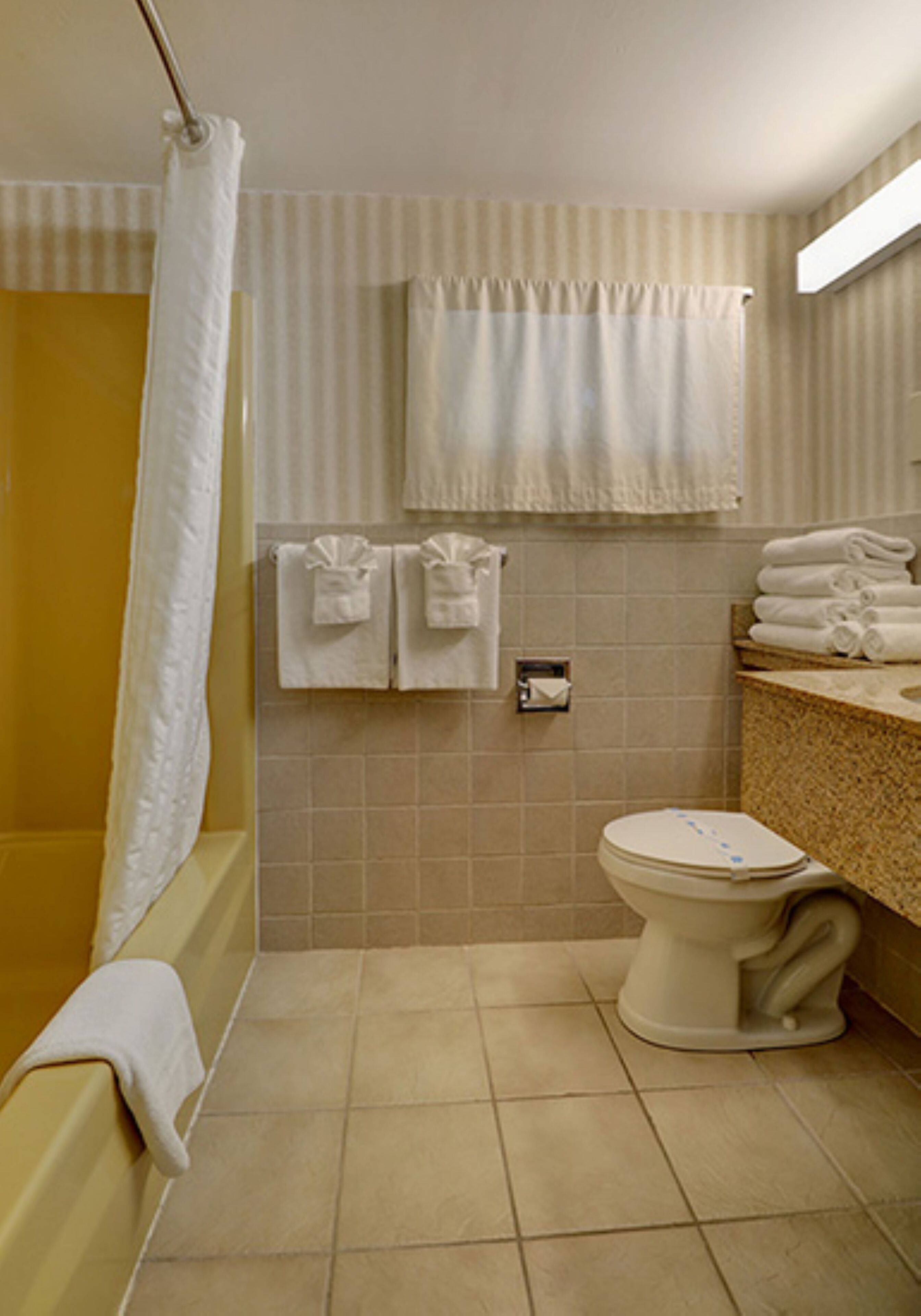 A bathroom with a bathtub, toilet, and sink.